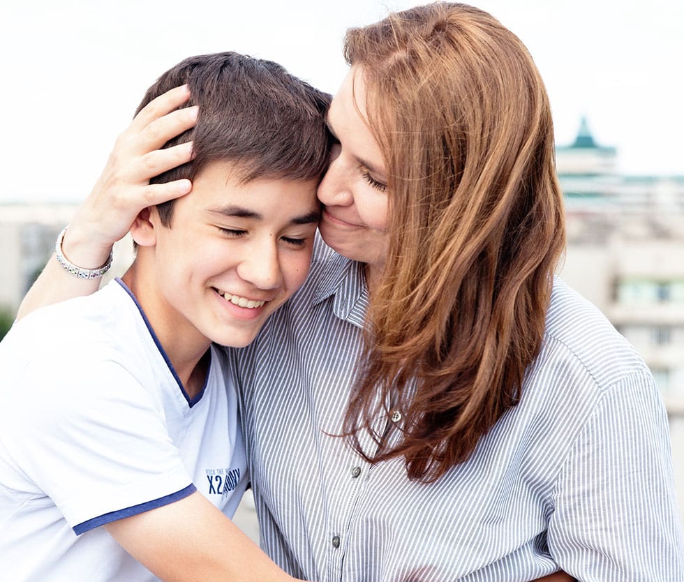 Teen and parent hugging after virtual IOP program