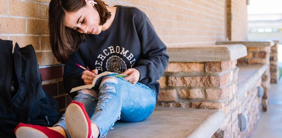 Teen girl journaling with headphones in